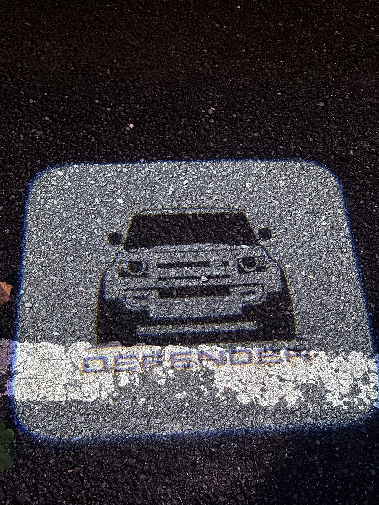 A imagem do New Defender de frente no espelho retrovisor do lado do passageiro.